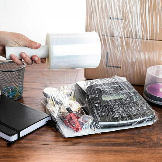 Hand holding stretch film roll packaging office supplies and boxes on wooden desk, MEGA USA