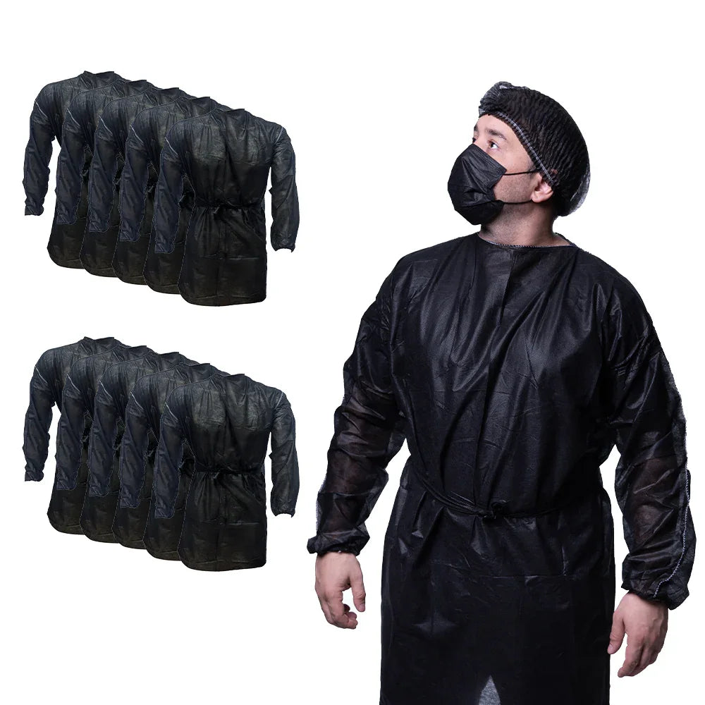 Man wearing black disposable hospital gown, mask, and bouffant cap with bulk gown packs