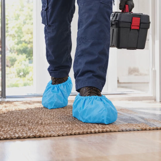 Technician walking into a home wearing TOTAL BLOK3R shoe covers